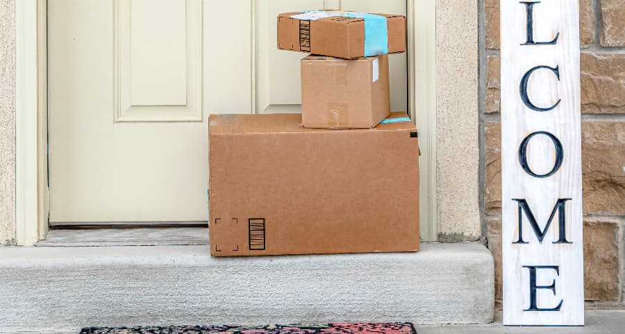 Packages on the doorstep of a home with a welcome sign in Brooklyn